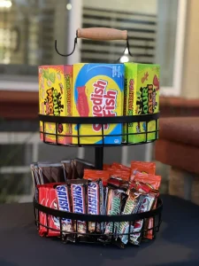Perfect for your outdoor cinema or open air movie night, this two-tiered metal basket holds boxes of Sour Patch Kids and Swedish Fish on top, with Snickers, Reese’s, and Kit Kat bars stocked below.